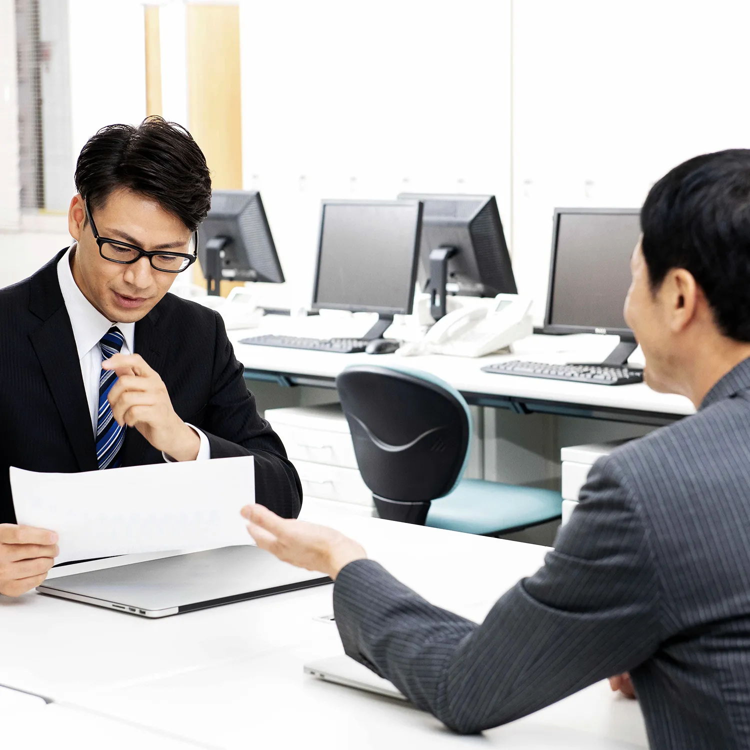 打ち合わせする二人の男性の写真